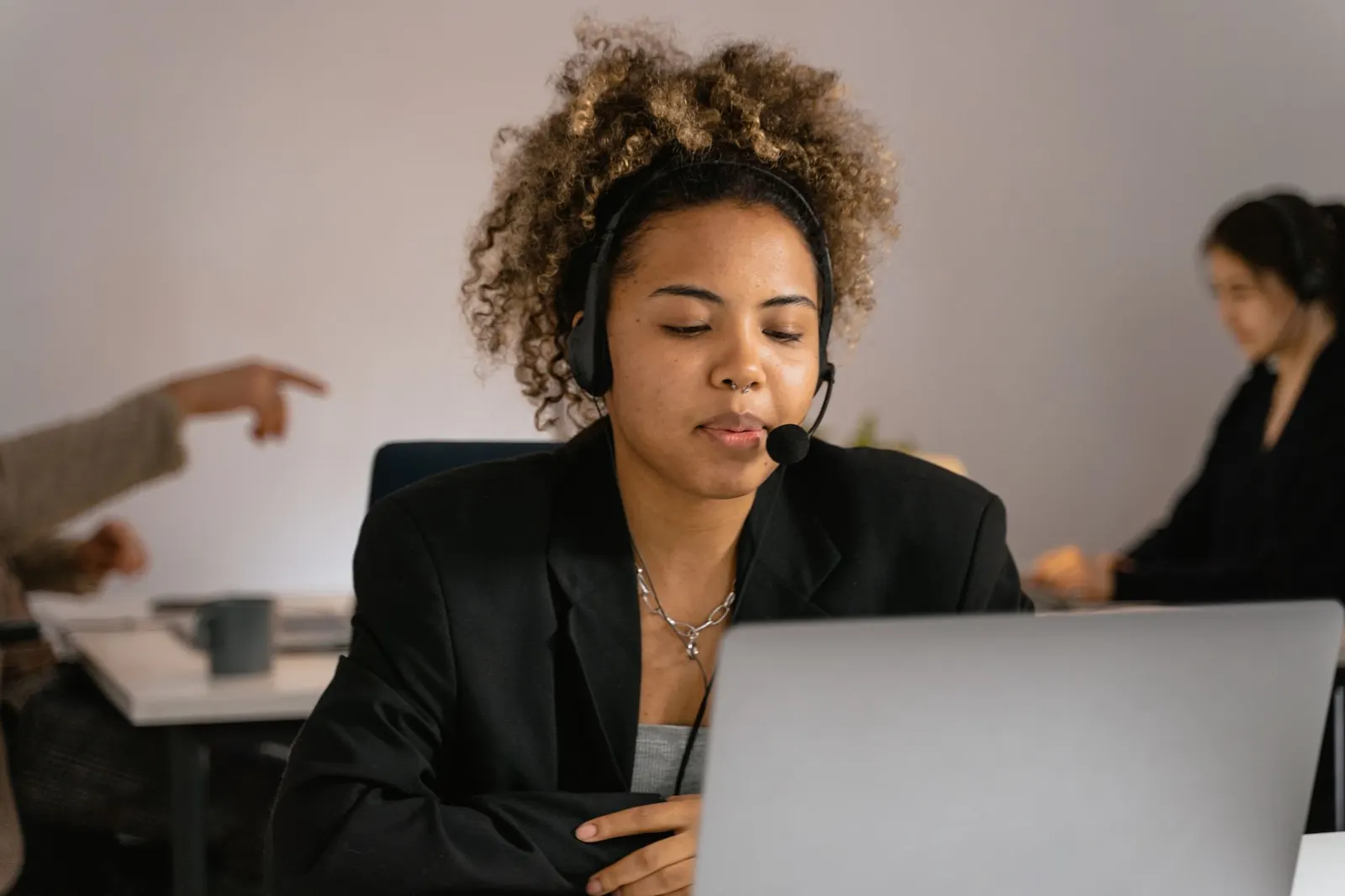 A woman working in a call centre with headphones on.