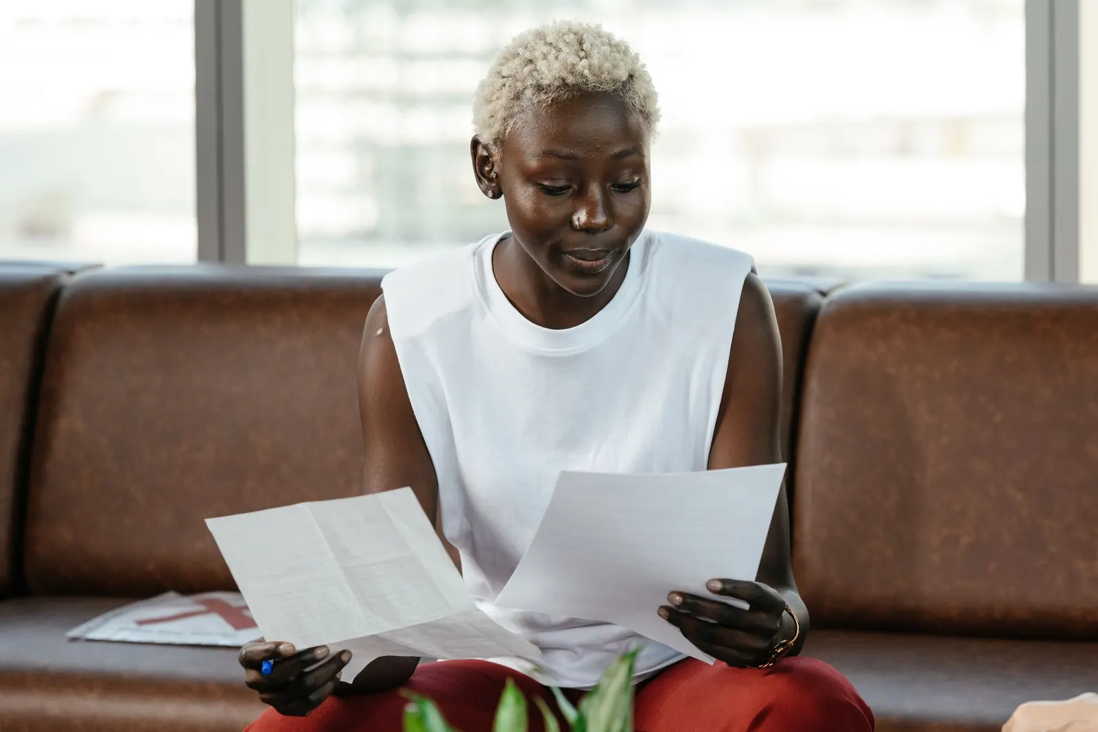 A woman carefully comparing two documents in an office.